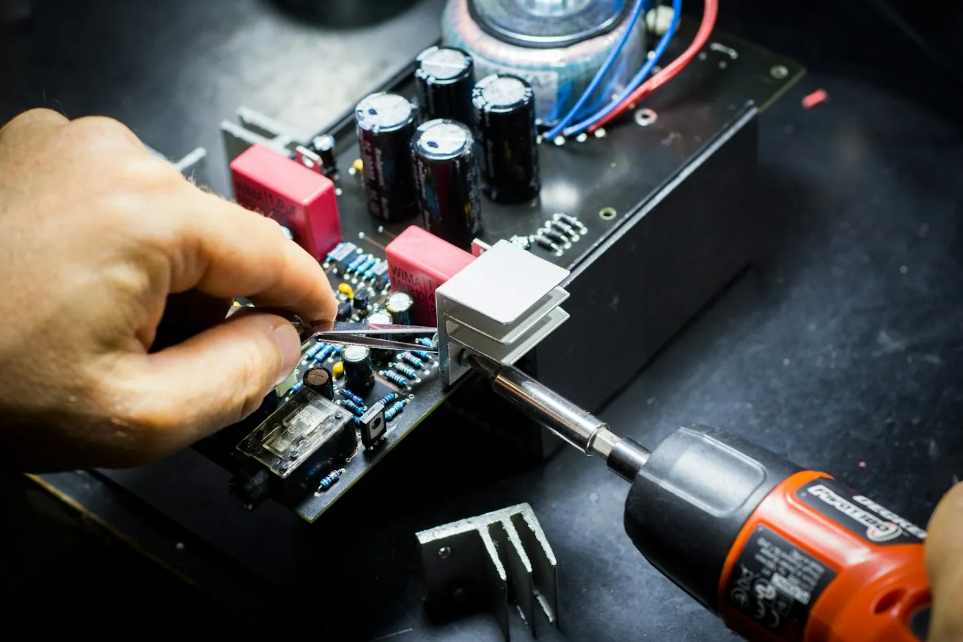 Técnico consertando uma placa eletrônica com chave de fenda