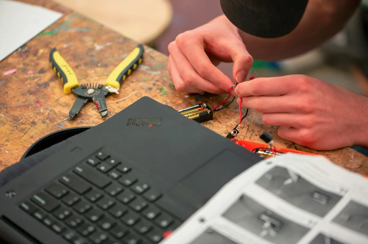 Mãos de técnico trabalhando em equipamento eletrônico na bancada